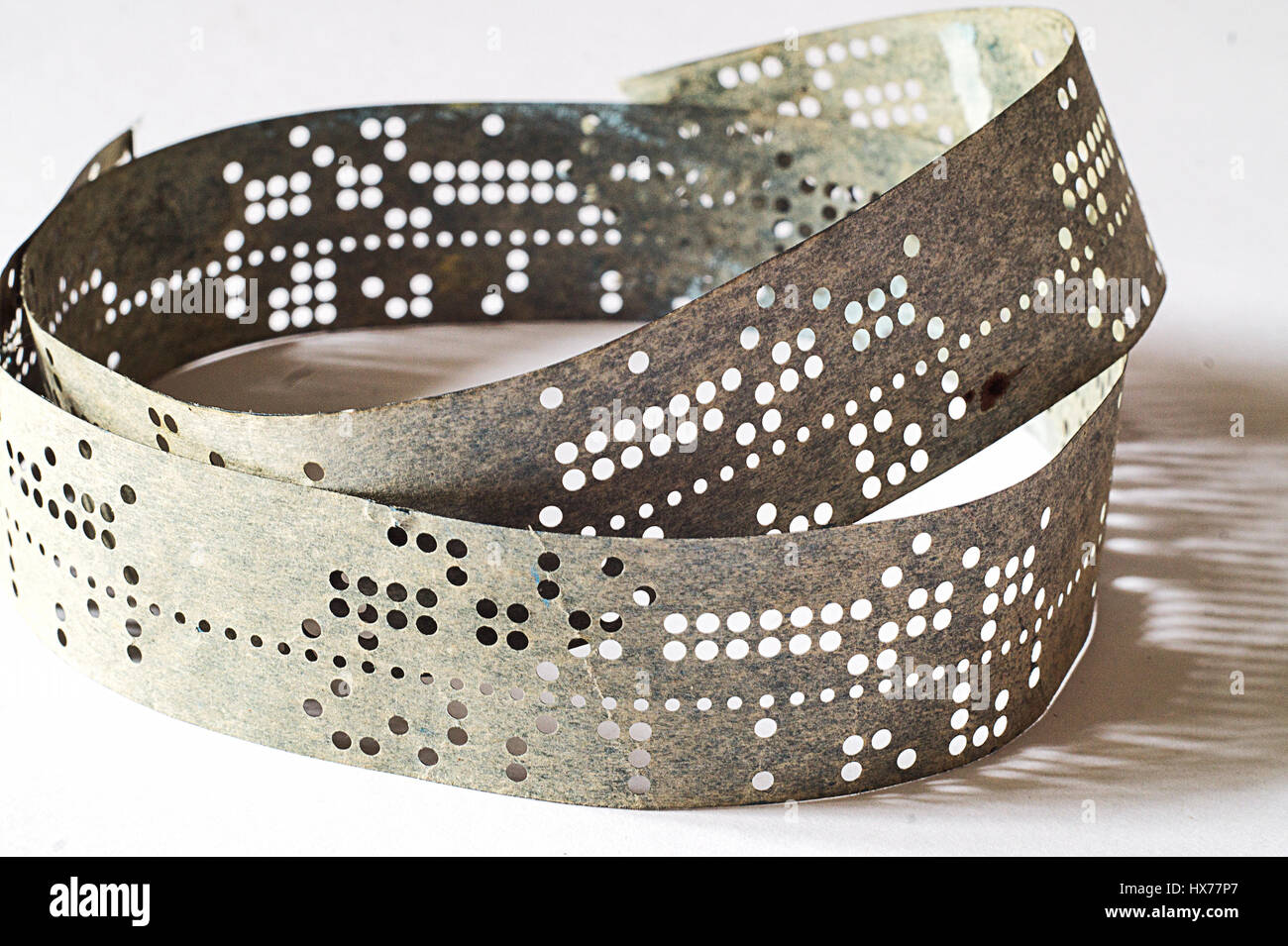 Strips of old punched tape on white surface Stock Photo Alamy