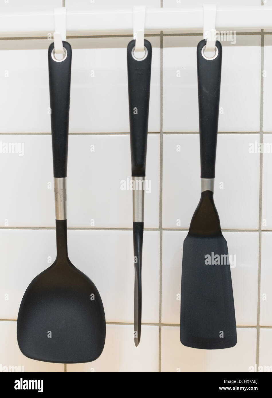 Black cooking utensils haning on the wall Stock Photo