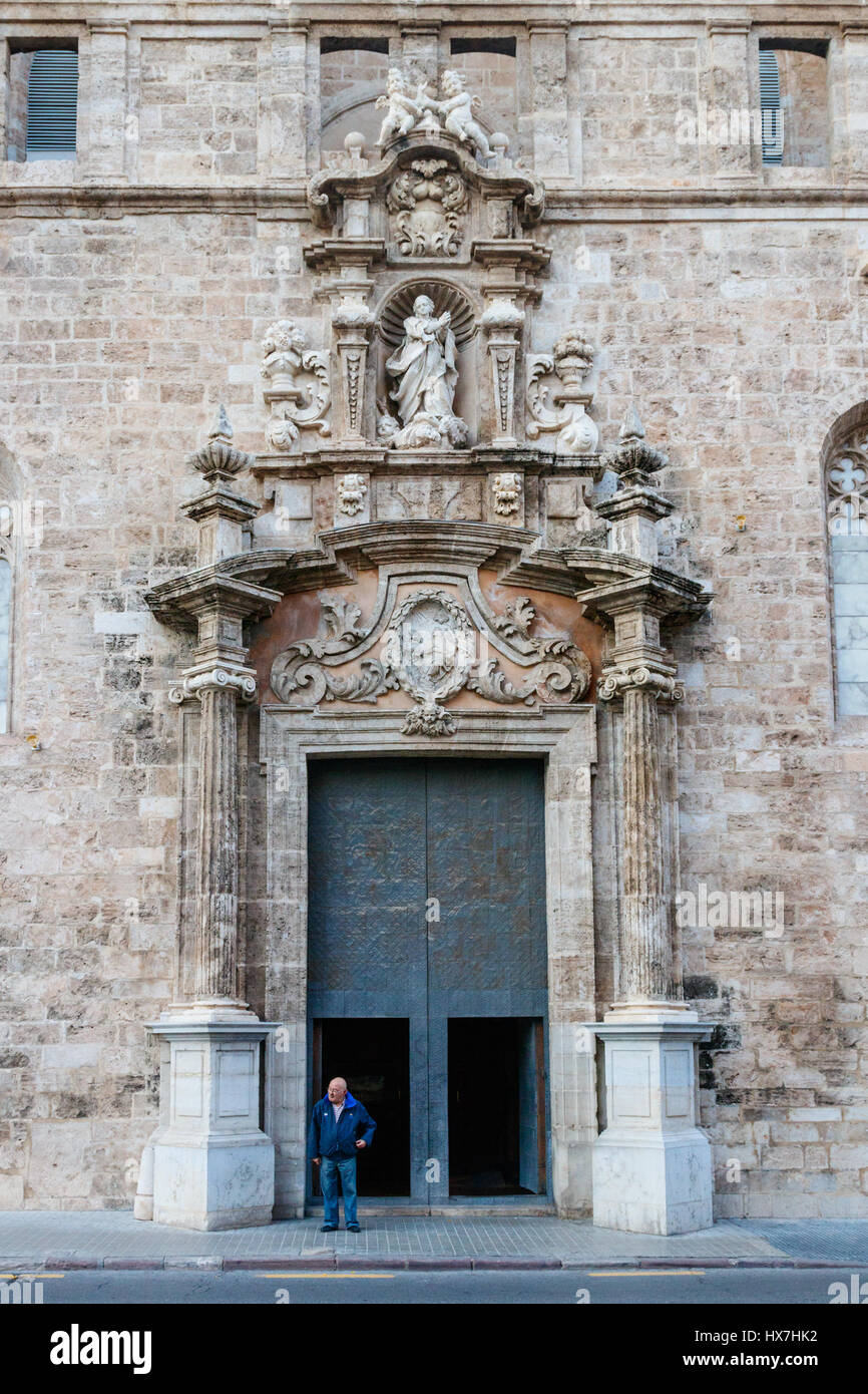 Unidentified local standing in the wicket of the monumental gate of the Los Santos Juan church. Valencia, Spain. Stock Photo