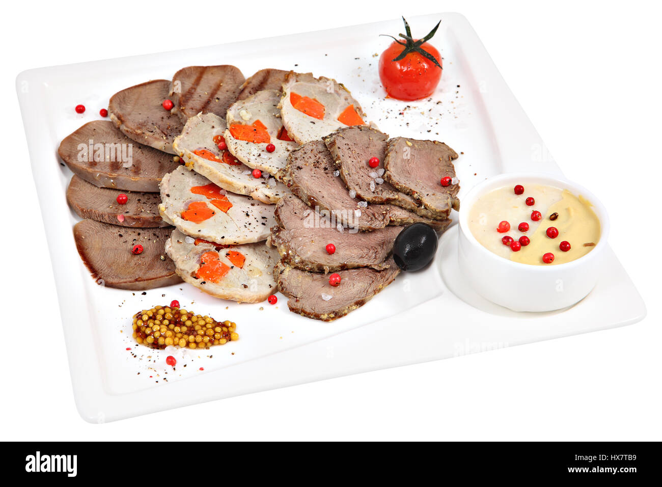 Meat assortment on a square white plate, isolated studio shot. Stock Photo