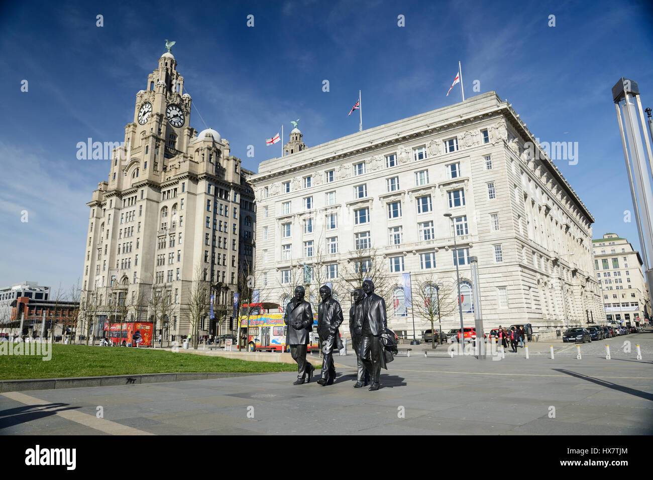 Statues of the famous Liverpool Group The Beatles situated in front of the iconic buildings at Pier Head in Liverpool. The Royal Liver Building (left) Stock Photo