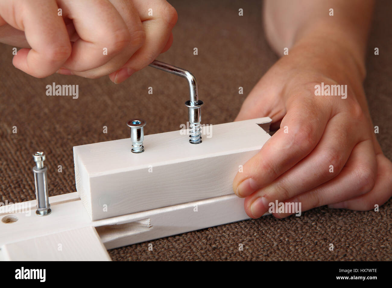 hand uses the allen key screws wood, Allen furniture key in hand. Allen