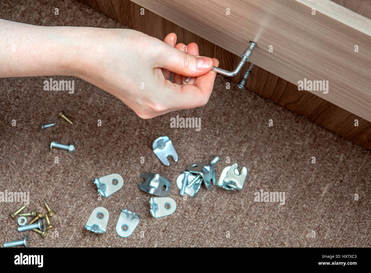 Selfassembly furniture, hand with an Allen key tighten screw Stock
