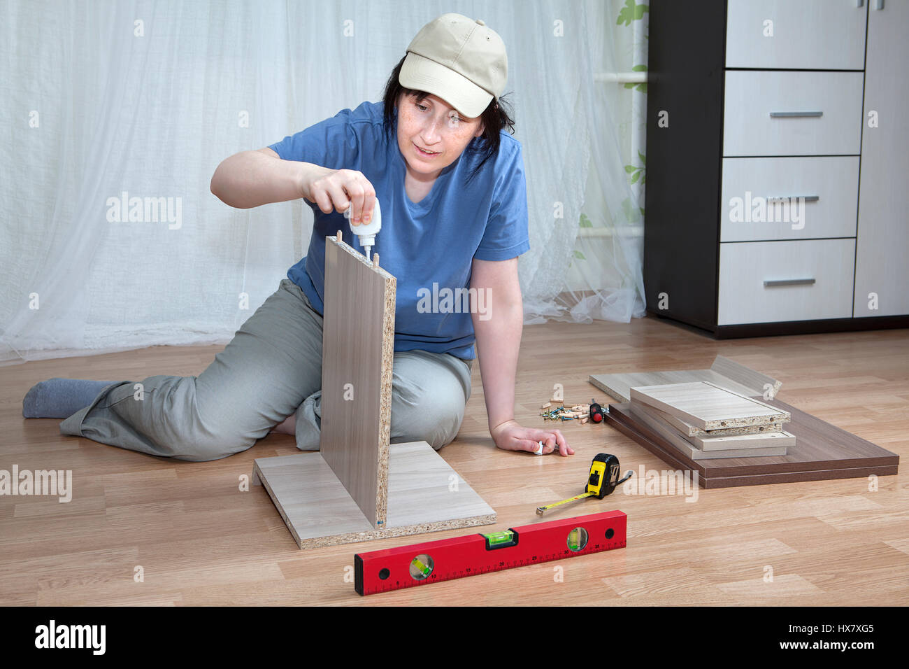 Woman putting together self assembly furniture assemble flat pack Stock