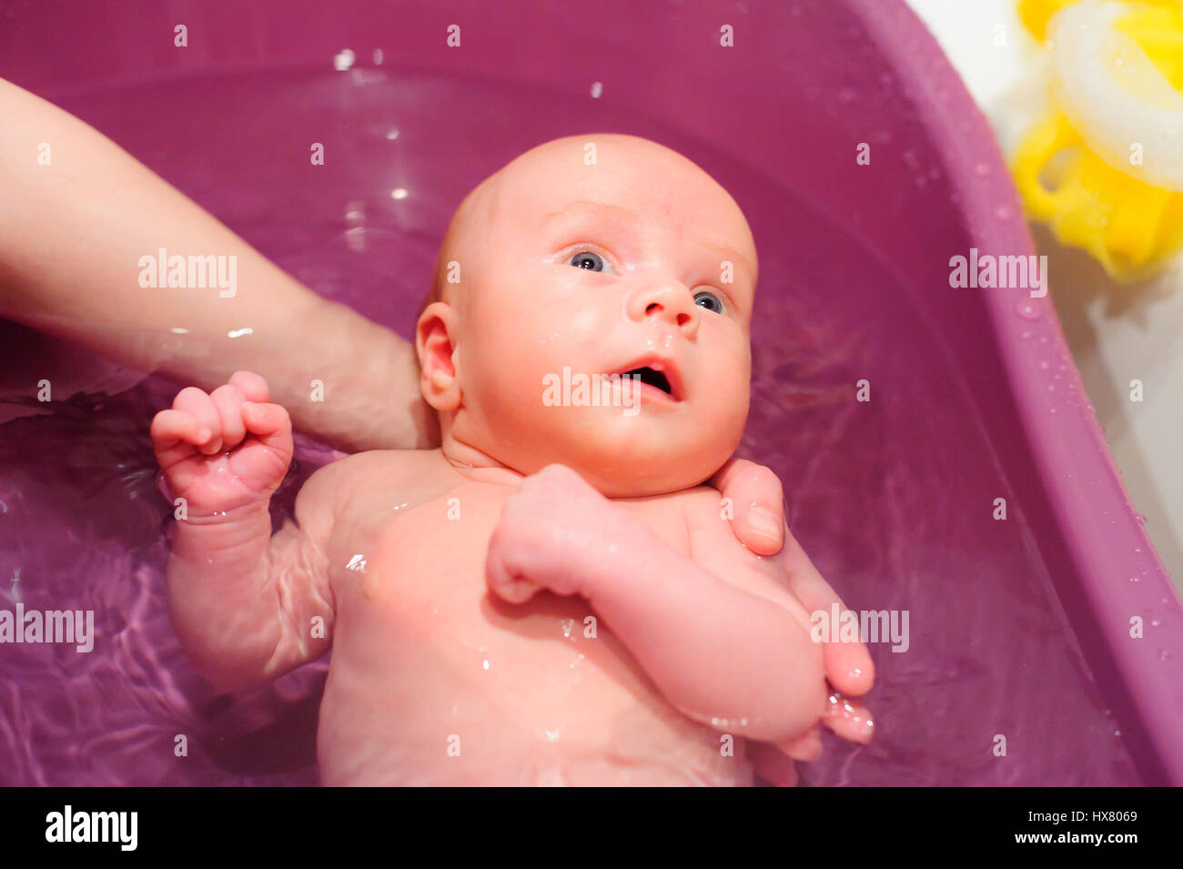 newborn baby swim in bathtub holding mother hand Stock Photo Alamy