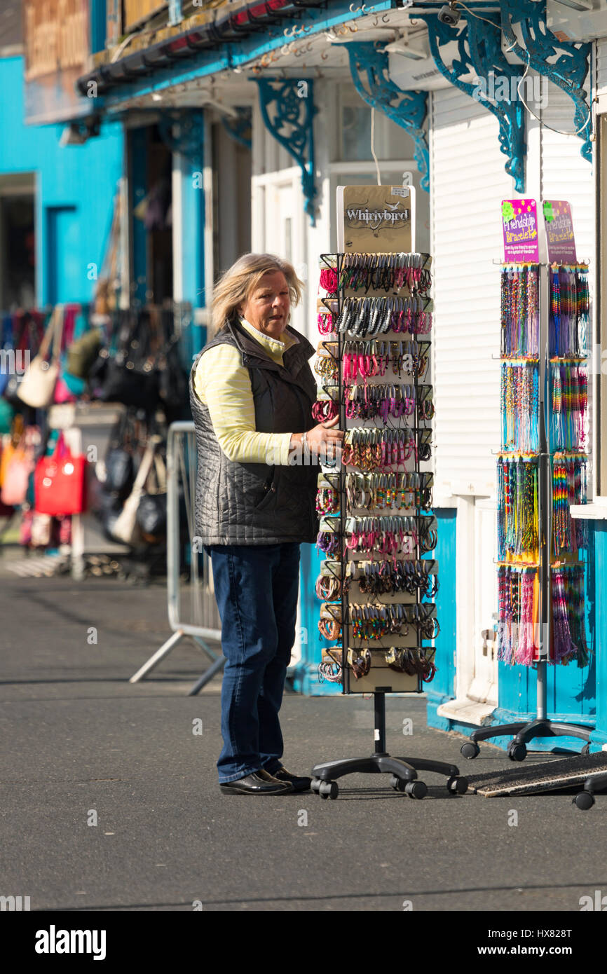 A Llandudno Pier stall owner opening up shop and placing display stands