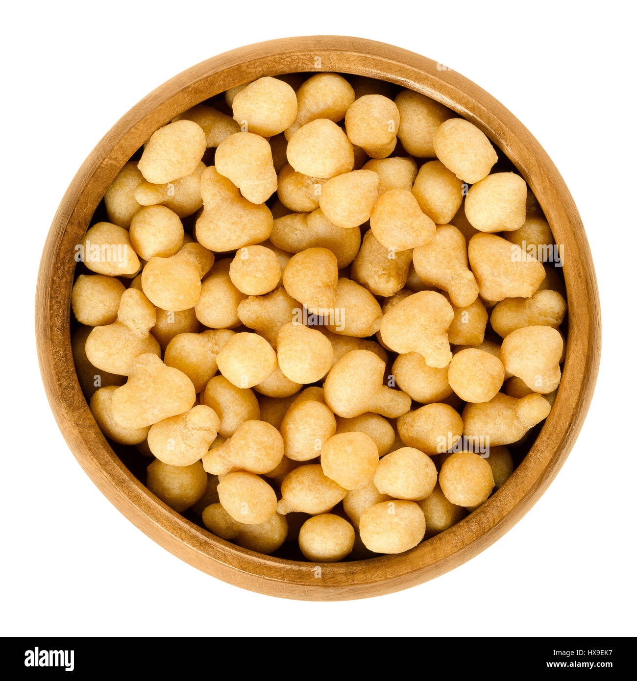 Fried batter pearls in a wooden bowl. Crispy pearls. A soup topping and snack product made from flour, vegetable fat and yeast. Isolated macro photo. Stock Photo