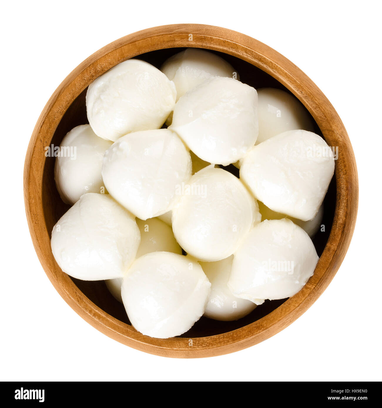 Small mozzarella balls in wooden bowl. Fresh white southern Italian cheese made from milk by the pasta filata method, also called bambini bocconcini. Stock Photo