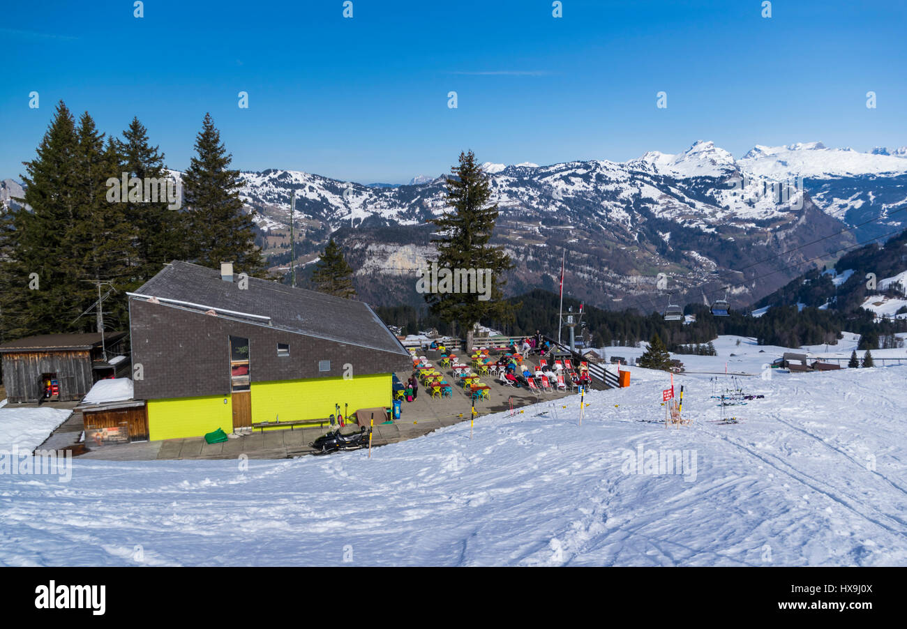 Restaurant Welesch with a large terrace, situated just next to a skiing slope in Stoos, Schwyz, Switzerland. Sunny day, mountain backdrop. Stock Photo