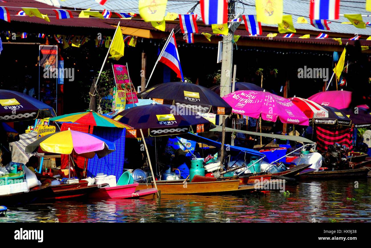 Amphawa, Thailand - December 17, 2010:  Colourful umbrellas provide shade to food vendors sitting in their docked boats at the Amphawa floating market Stock Photo