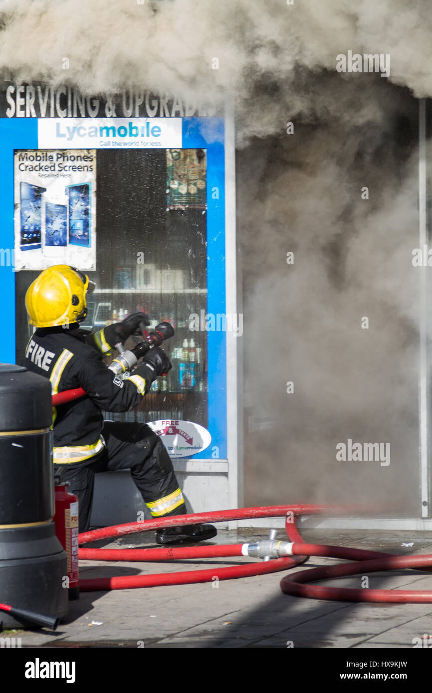 Ilford, UK. 25th Mar, 2017. Saturday 25/03/17 Six fire engines and around 30 firefighters tackled a blaze in a retail premises on Cranbrook Road in Ilford, The Brigade were called at around 3pm on Saturday afternoon. The fire resulted in the road being closed to traffic whilst fire crews dealt with the blaze. It is understood that the blaze was caused by an electrical fault and is being investigated by London Fire Brigade There are thought to be no injuries as a result of the blaze, London Ambulance Service sent several units to the scene of the blaze. Credit: Ian Marlow/Alamy Live News Stock Photo
