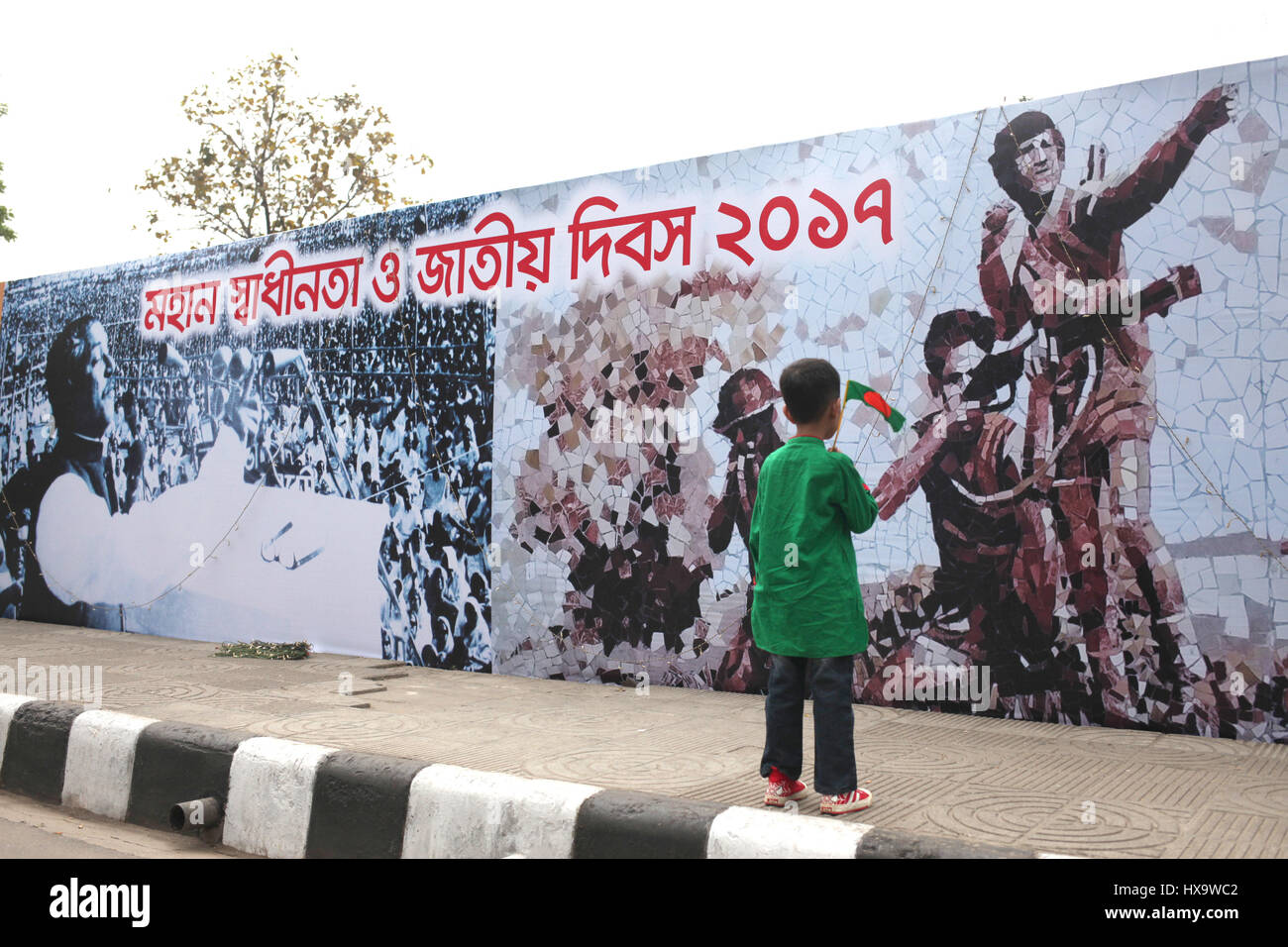 Dhaka, Bangladesh. 26th Mar, 2017. 26 March 2017 Dhaka, Bangladesh ''“ A Bangladeshi children hold a national flag and to see the wallstreet painting during the nation celebrate 46 Independence Day on 26 March 2017 Dhaka, Bangladesh. In 1971 when the Pakistani occupation forces kicked off one of the worst genocides in history that led to a nine-month war for the independence of Bangladesh in 1971. © Monirul Alam Credit: Monirul Alam/ZUMA Wire/Alamy Live News Stock Photo