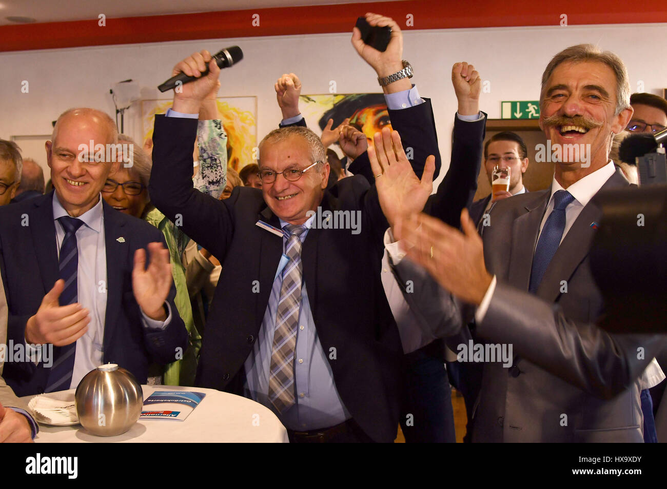 Voelkingen, Germany. 26th Mar, 2017. Rolf Mueller (L-R) main candidate for Alternatives for Germany (AfD) political party looks happy with party state manager Dieter Mueller and regional chairman for Rhineland-Palatinate Uwe Junge as the first results come in after the German state of Saarland's parliamentary elections in Voelkingen, Germany, 26 March 2017. Photo: Harald Tittel/dpa/Alamy Live News Stock Photo