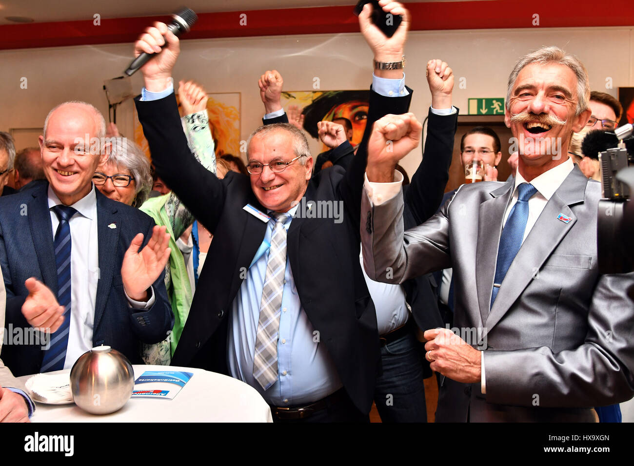 Voelklingen, Germany. 26th Mar, 2017. Rolf Mueller (L-R), main candidate for the Alternative for Germany (AfD) political party, celebrates with state-level party manager Dieter Mueller and Uwe Junge, AfD chairman in the German state Rhineland-Palatinate, as the first results come in after the German state of Saarland's parliamentary elections in Voelklingen, Germany, 26 March 2017. Photo: Harald Tittel/dpa/Alamy Live News Stock Photo