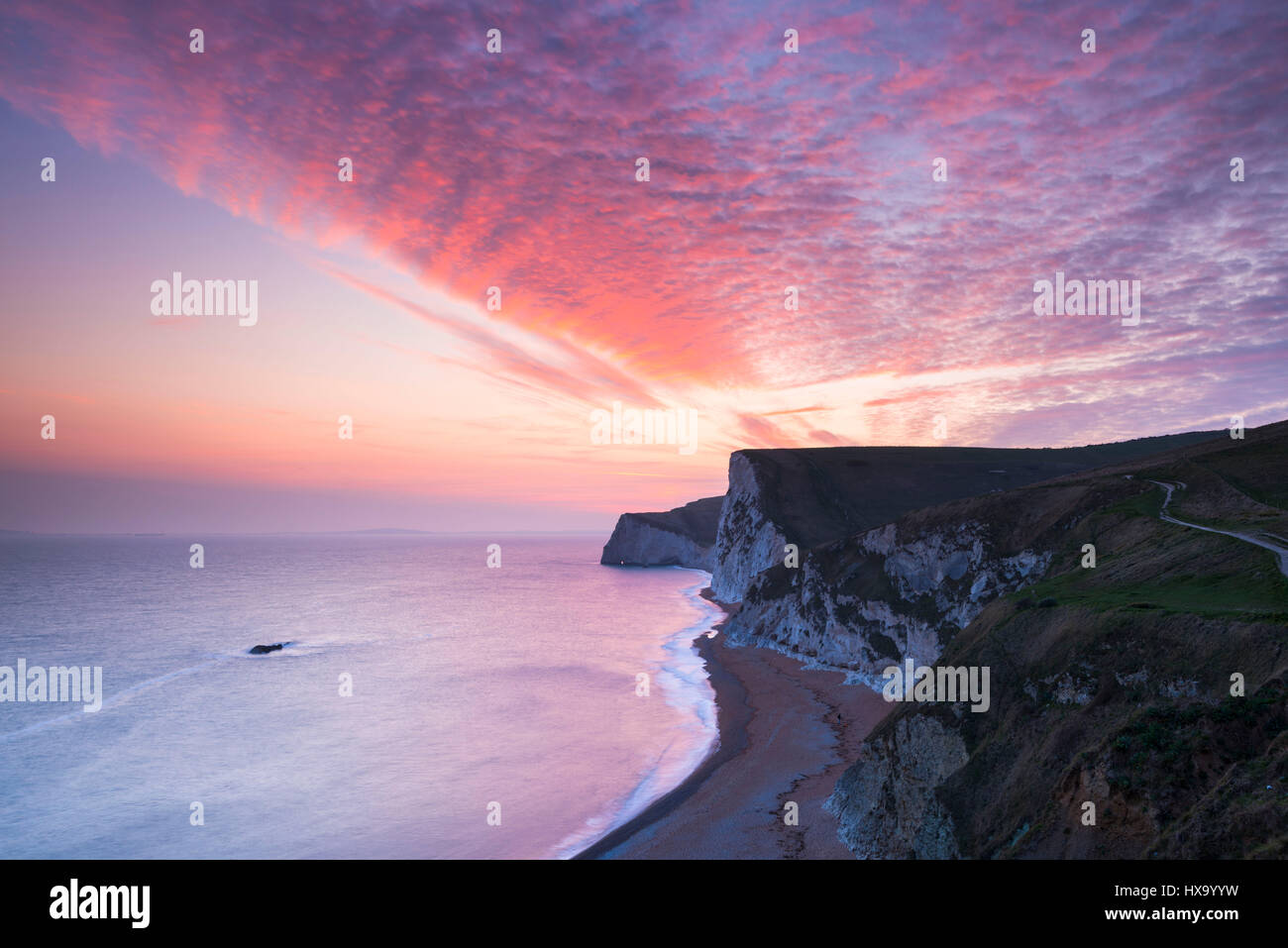 Lulworth, Dorset, UK. 26th March, 2017. UK Weather. Spectacular sunset above the chalk cliffs of Swyre Head and Bats Head, viewed from Durdle Door near Lulworth on the Dorset Jurassic Coast. Photo Credit: Graham Hunt/Alamy Live News Stock Photo