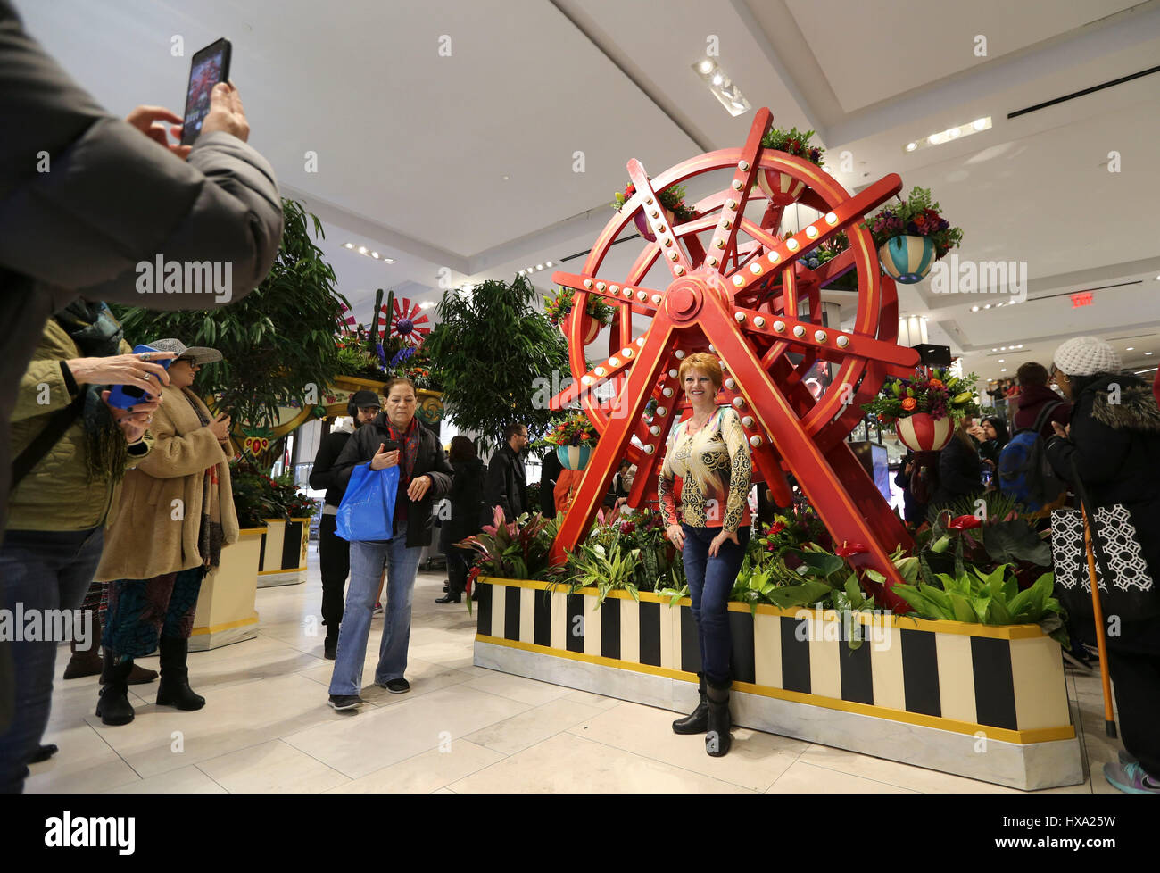 New York, USA. 26th Mar, 2017. A woman poses for photos at the Macy's Herald Square store where the 'carnival' themed Macy's flower show kicked off, in Manhattan, New York, the United States, March 26, 2017. The 'carnival' themed Macy's flower show kicked off here on Sunday. The 15-day show, with floral arrangements and organic installations inspired from the iconic American carnival, makes people feel like losing themselves in the quirks and delights of early 20th century fairs. Credit: Wang Ying/Xinhua/Alamy Live News Stock Photo