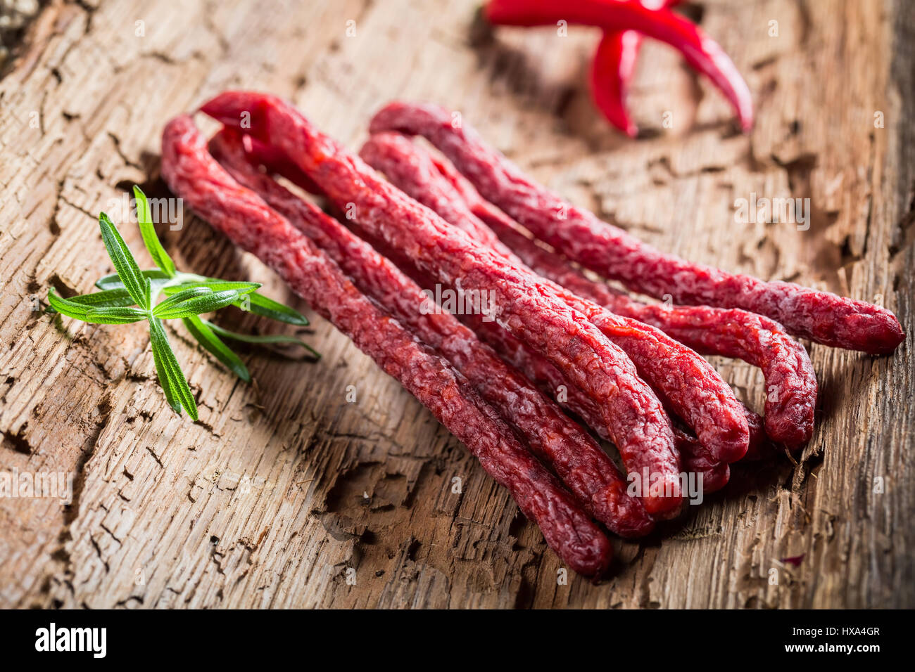 Homemade thin sausages in rural storeroom on bark Stock Photo