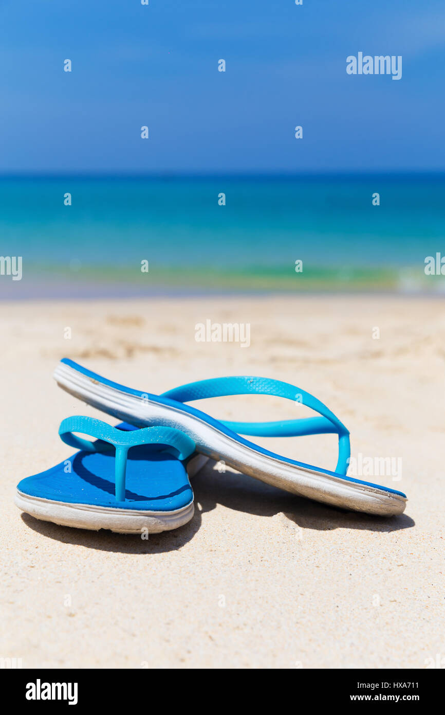 Blue slippers on the white sand beach Stock Photo - Alamy