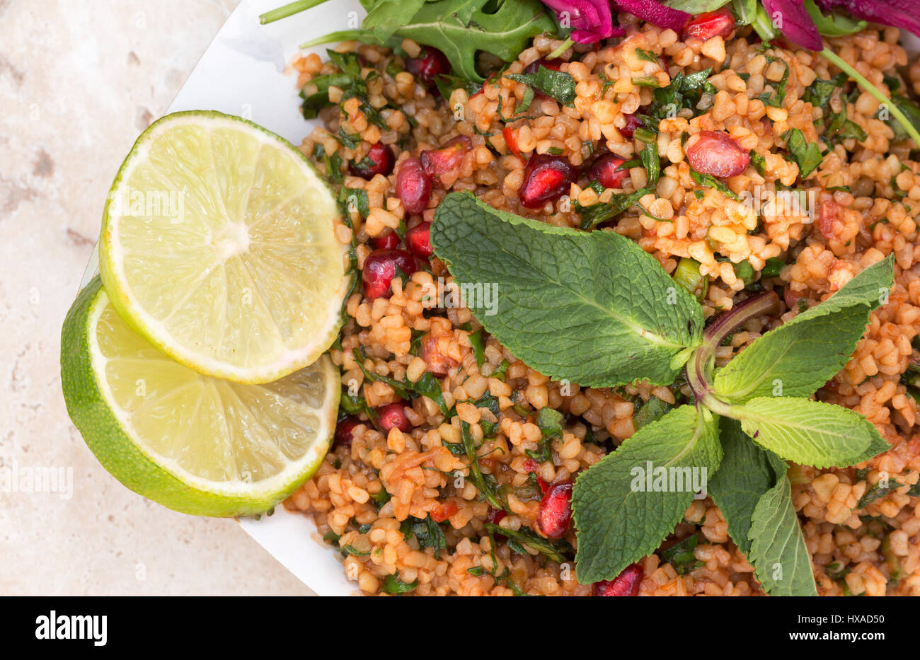 Vegetarian food - Middle eastern food consisting of Bulgur Wheat salad, rocket, pickled cabbage limes and mint - concept - healthy eating Stock Photo