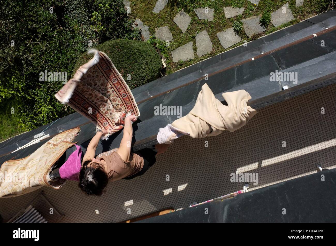 AJAXNETPHOTO. LOUVECIENNES, FRANCE. -DOMESTIC SCENE- WOMAN SHAKING CARPET FROM BALCONY OF RESIDENTIAL TOWER BLOCK. PHOTO:JONATHAN EASTLAND/AJAX REF:FX112103 5145 Stock Photo