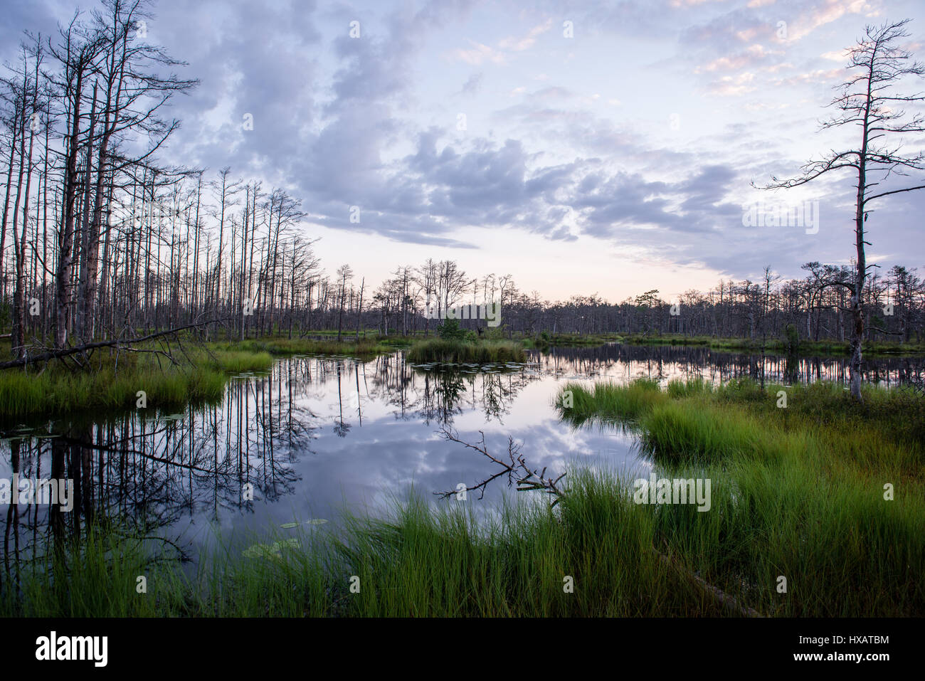 reflections in the lake water at sunrise with clouds and dramatic ...