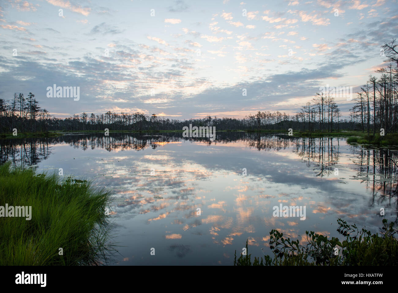 reflections in the lake water at sunrise with clouds and dramatic ...