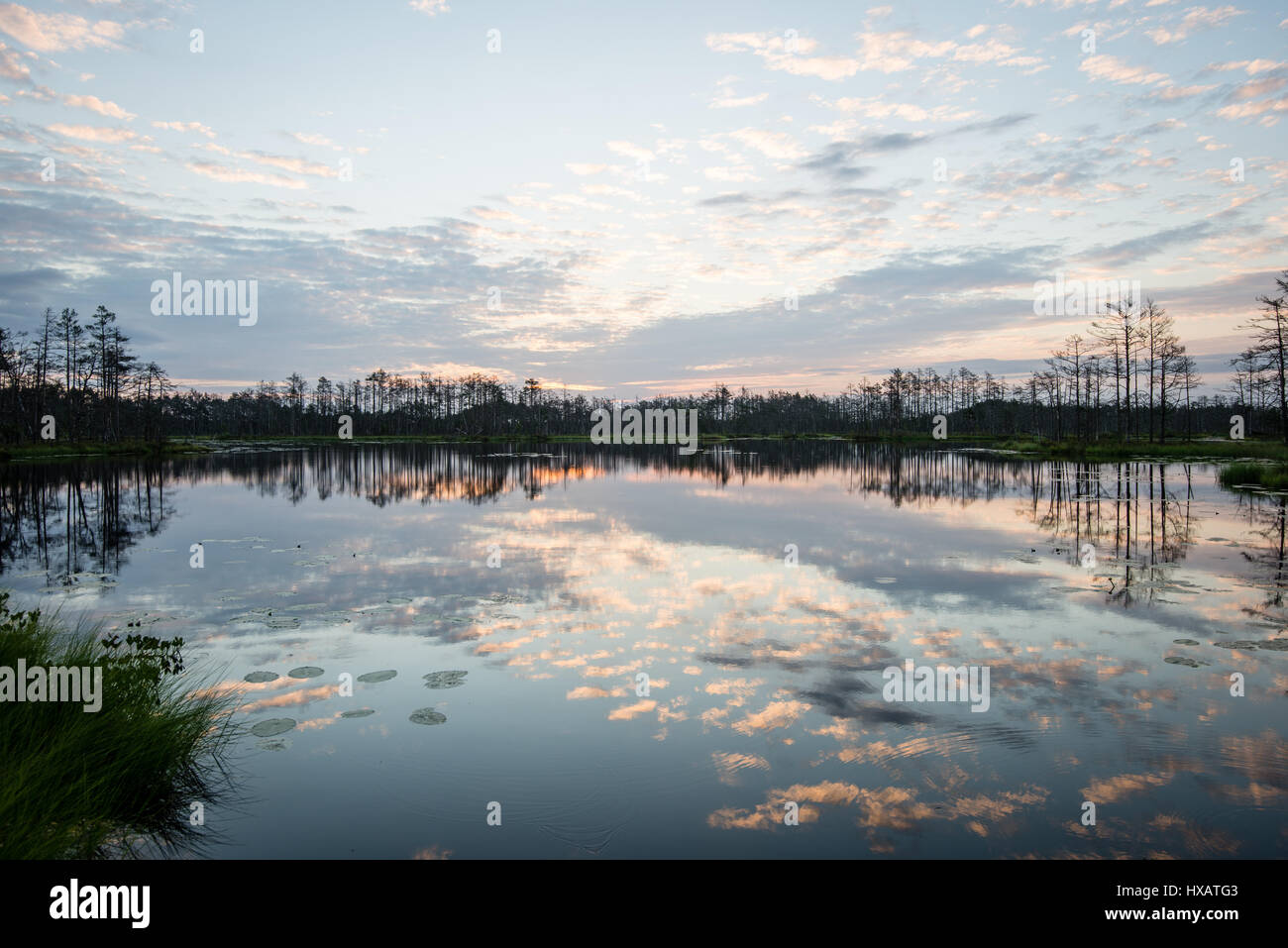 reflections in the lake water at sunrise with clouds and dramatic ...