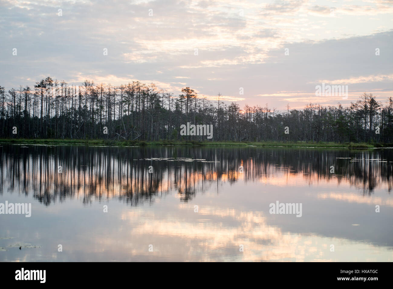 reflections in the lake water at sunrise with clouds and dramatic ...