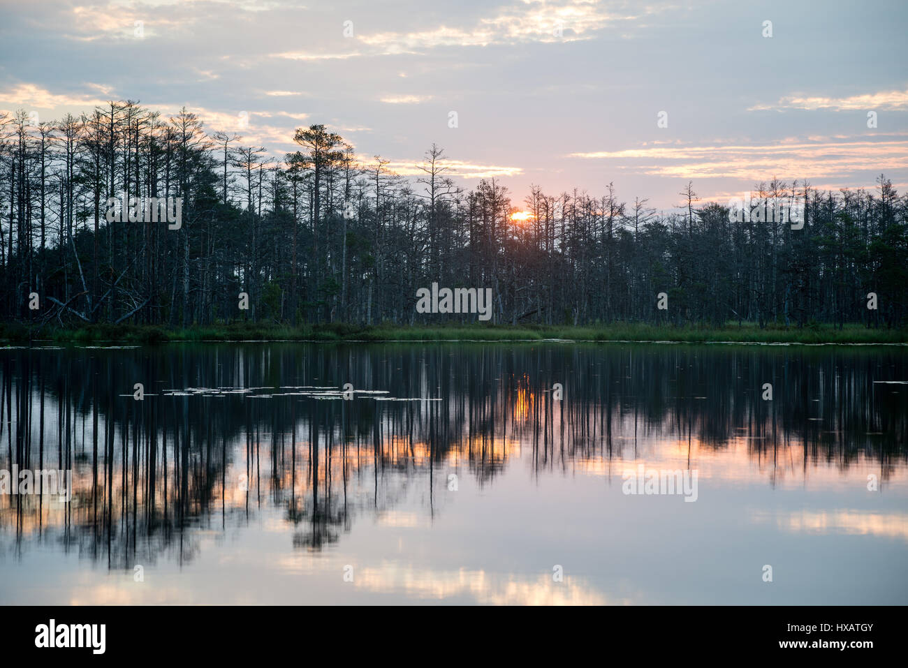 reflections in the lake water at sunrise with clouds and dramatic ...