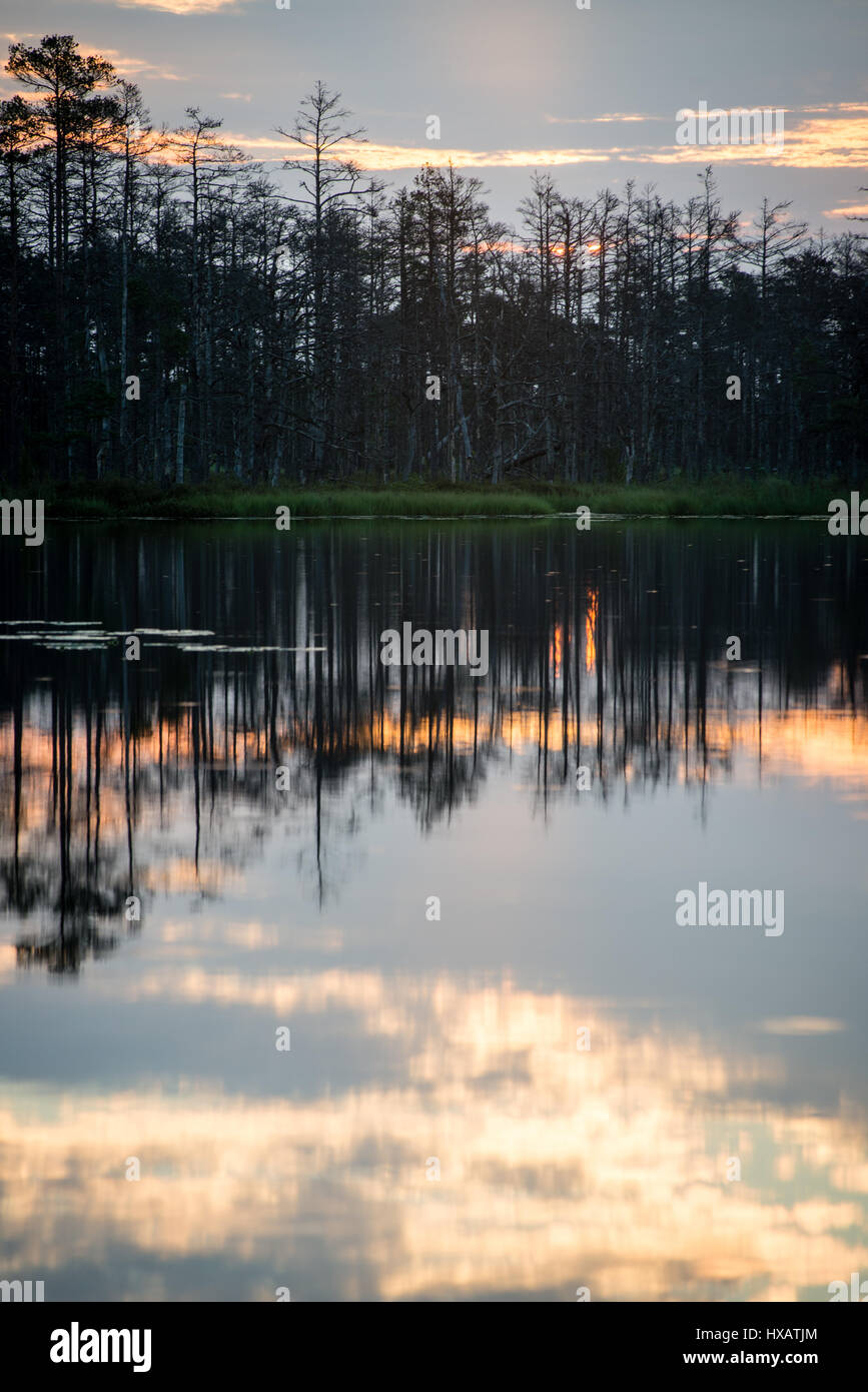 reflections in the lake water at sunrise with clouds and dramatic ...