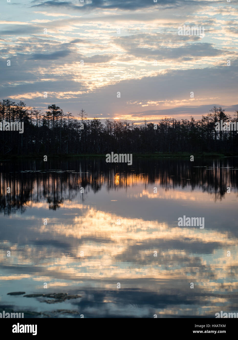 reflections in the lake water at sunrise with clouds and dramatic ...