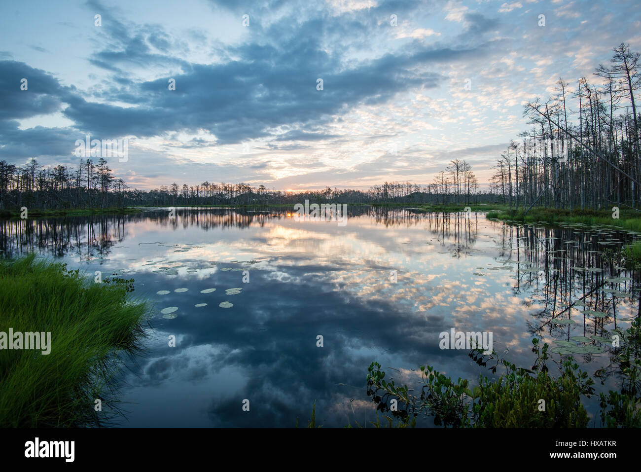 reflections in the lake water at sunrise with clouds and dramatic ...