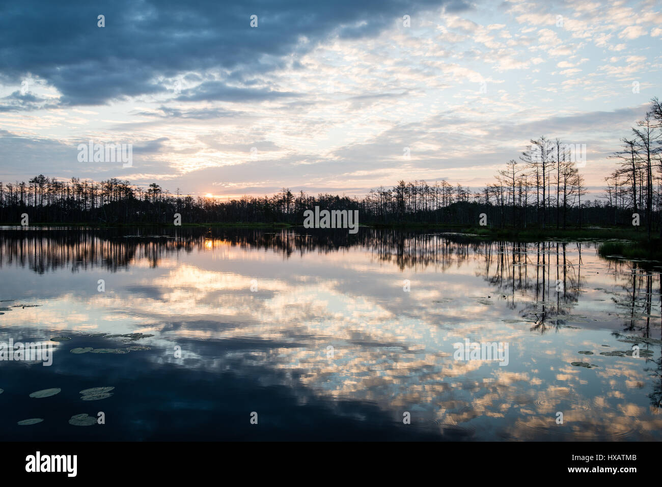 reflections in the lake water at sunrise with clouds and dramatic ...