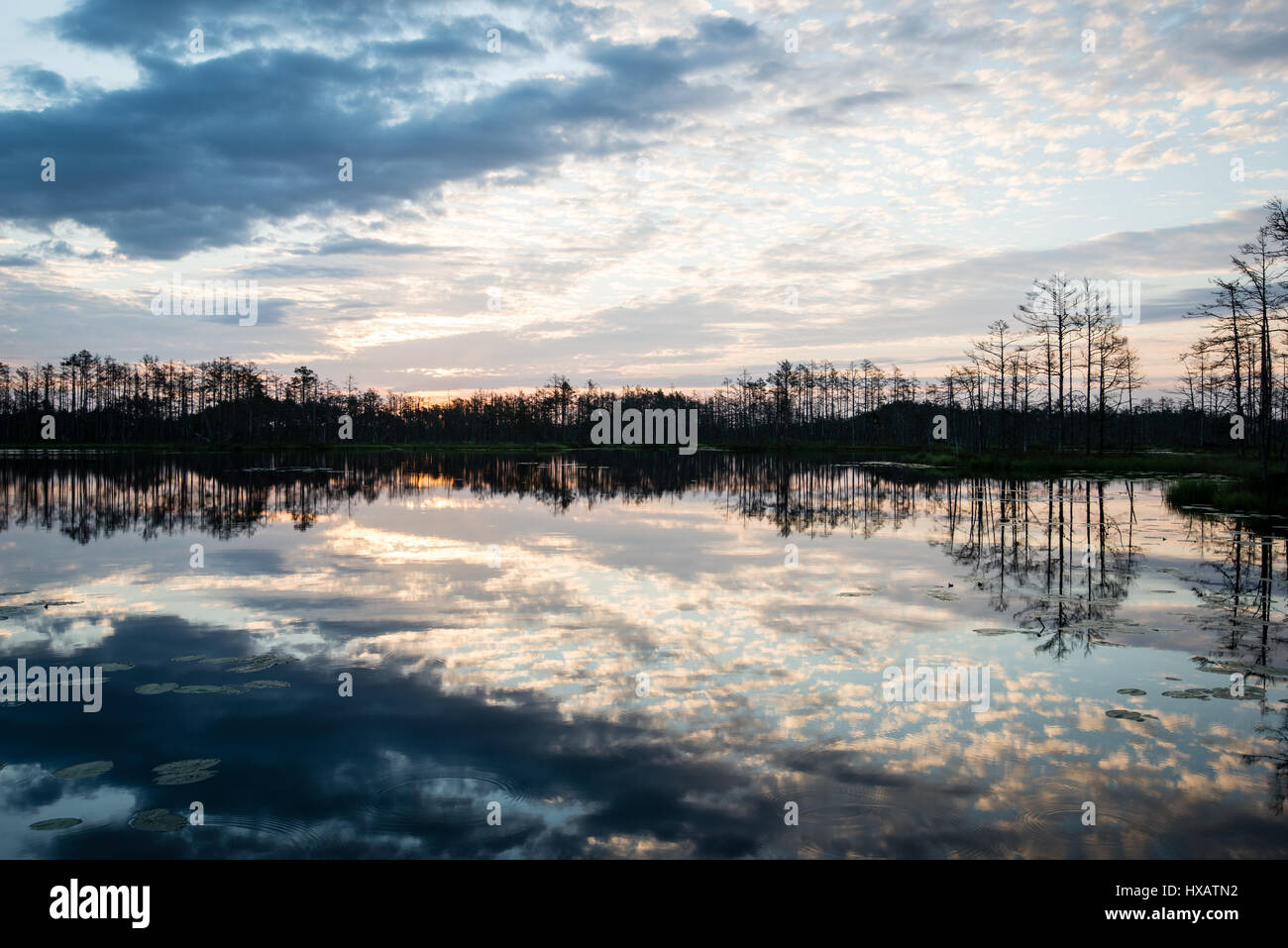 reflections in the lake water at sunrise with clouds and dramatic ...