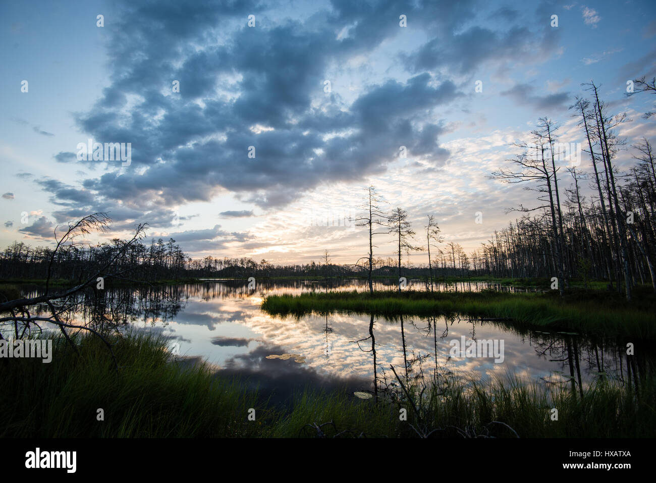 reflections in the lake water at sunrise with clouds and dramatic ...