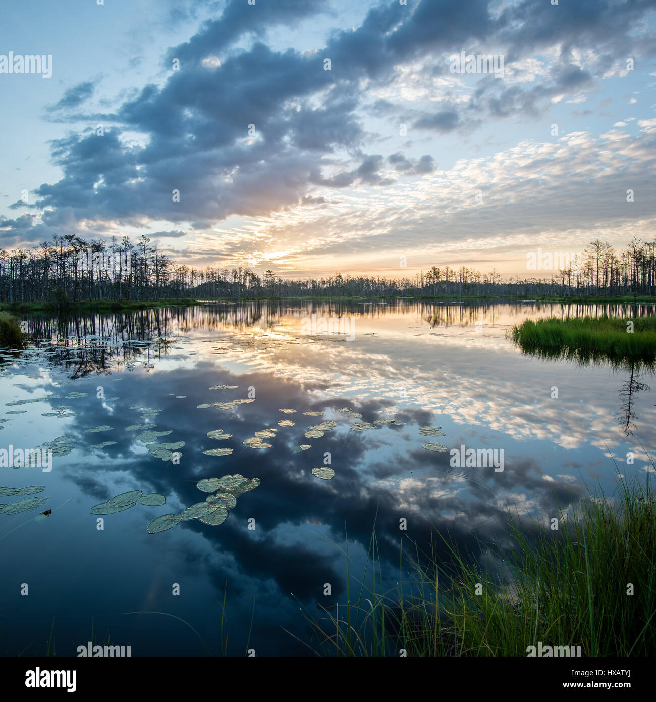 reflections in the lake water at sunrise with clouds and dramatic ...