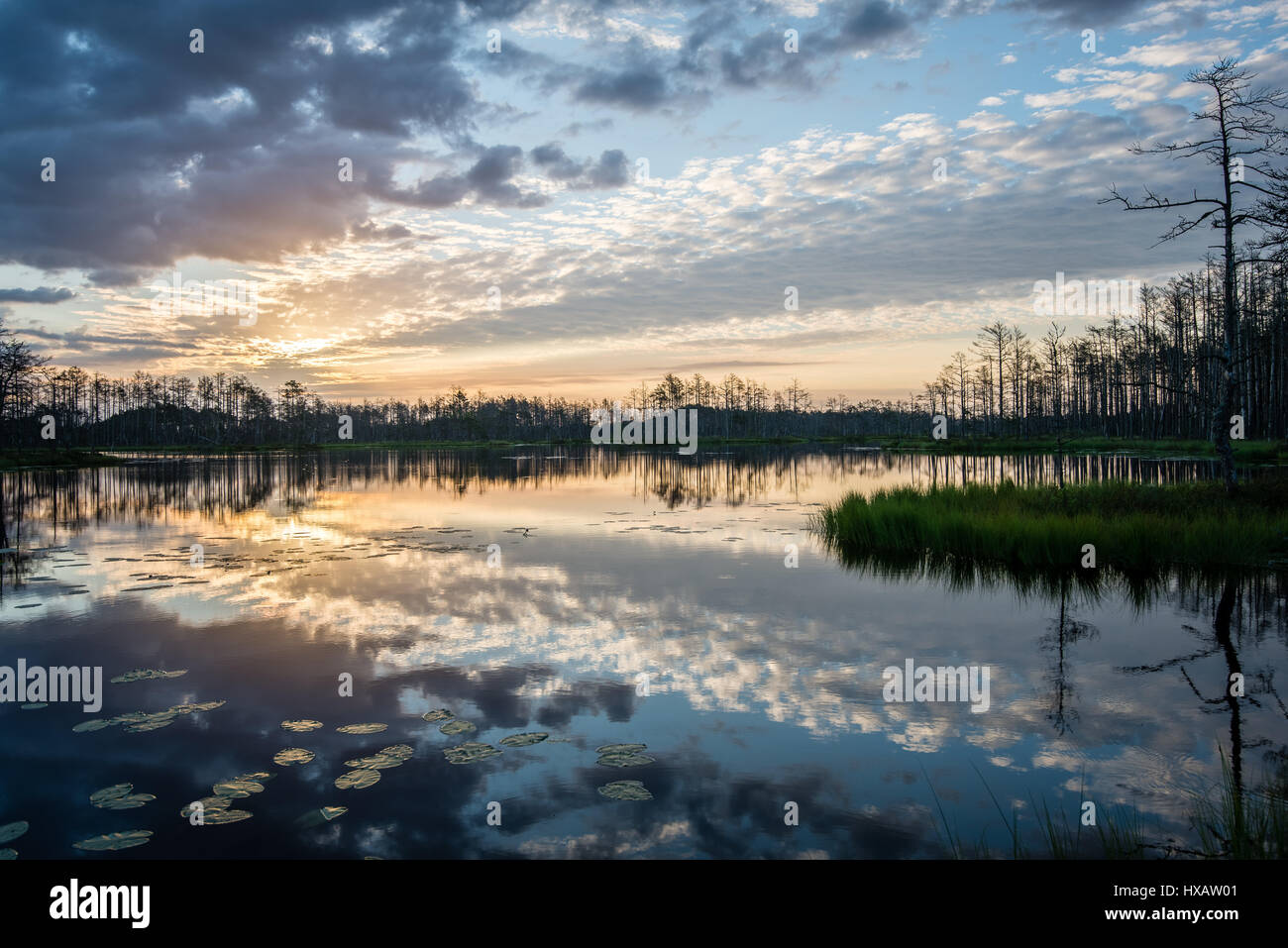 reflections in the lake water at sunrise with clouds and dramatic ...