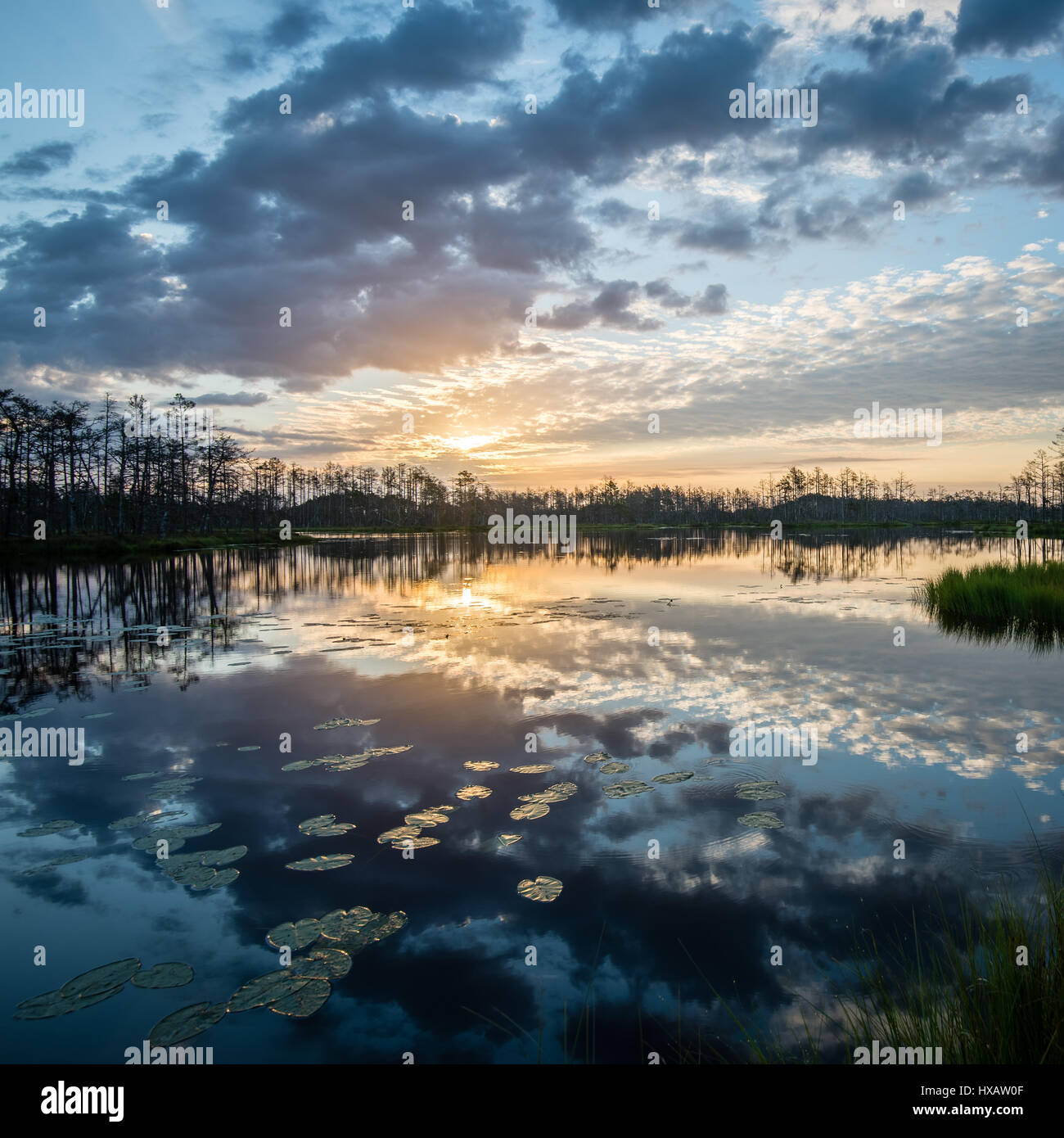 reflections in the lake water at sunrise with clouds and dramatic ...