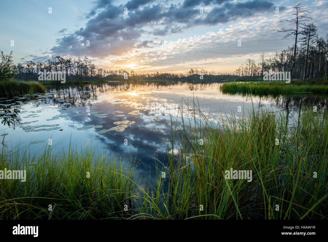 reflections in the lake water at sunrise with clouds and dramatic ...