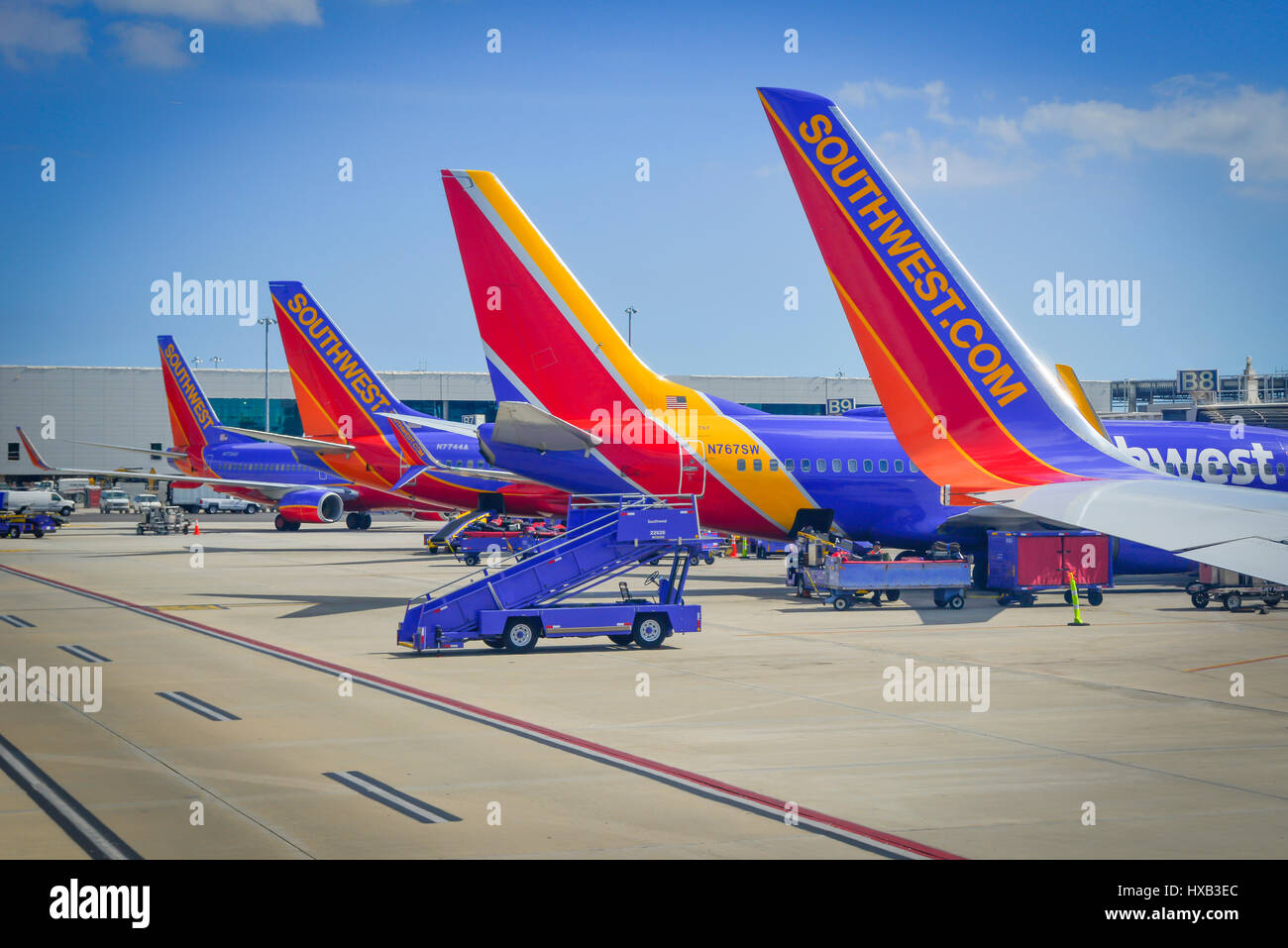 View of parked commercial airplanes at gates being serviced and having luggage loadied in preparation for flight Stock Photo