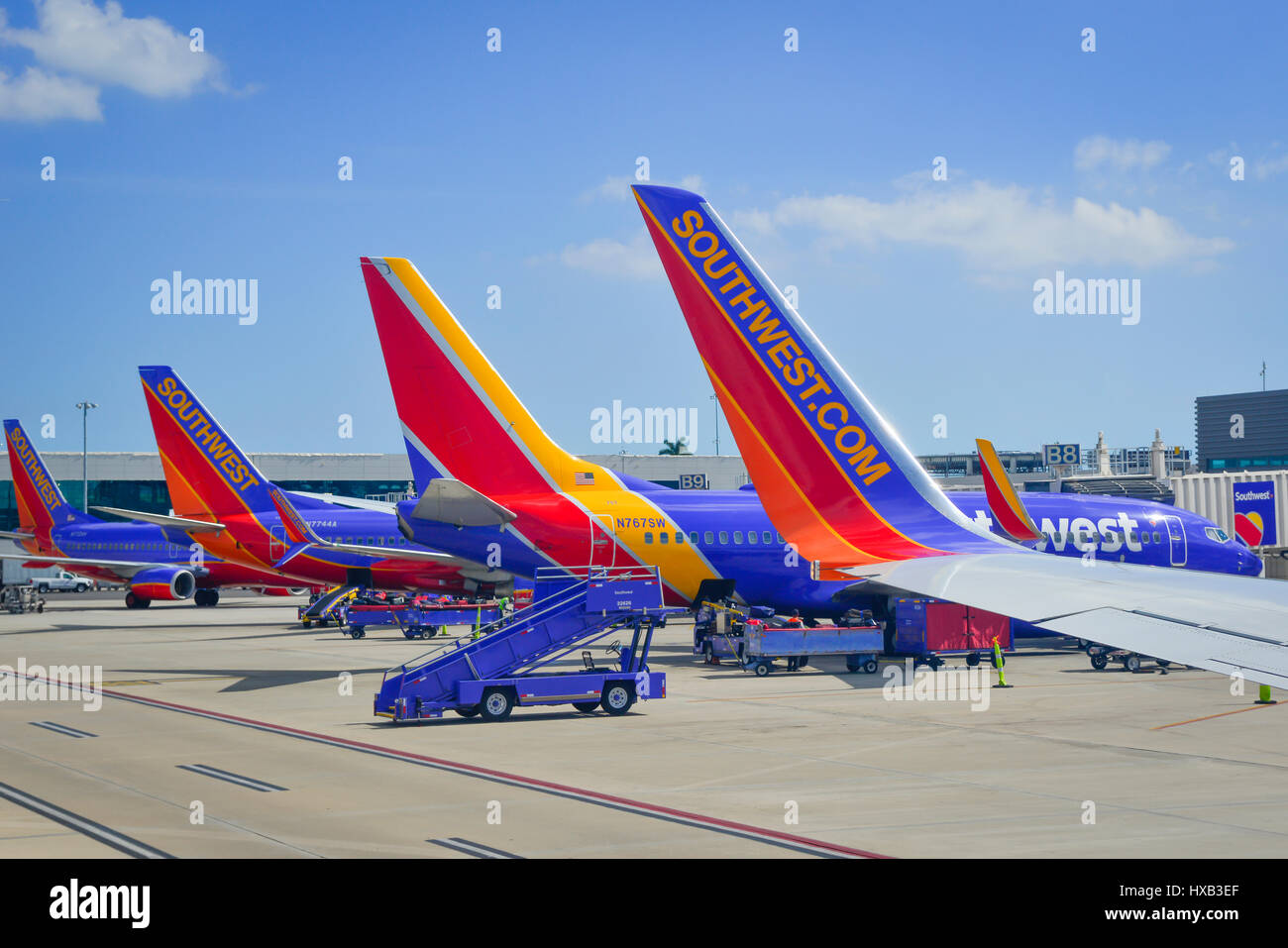 View of parked commerical airplanes at gates being serviced and having luggage loadied in preparation for flight Stock Photo