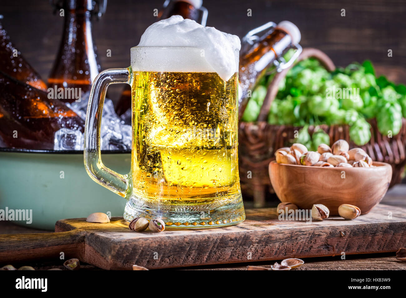 Fresh and cold beer with nuts on old wooden table Stock Photo