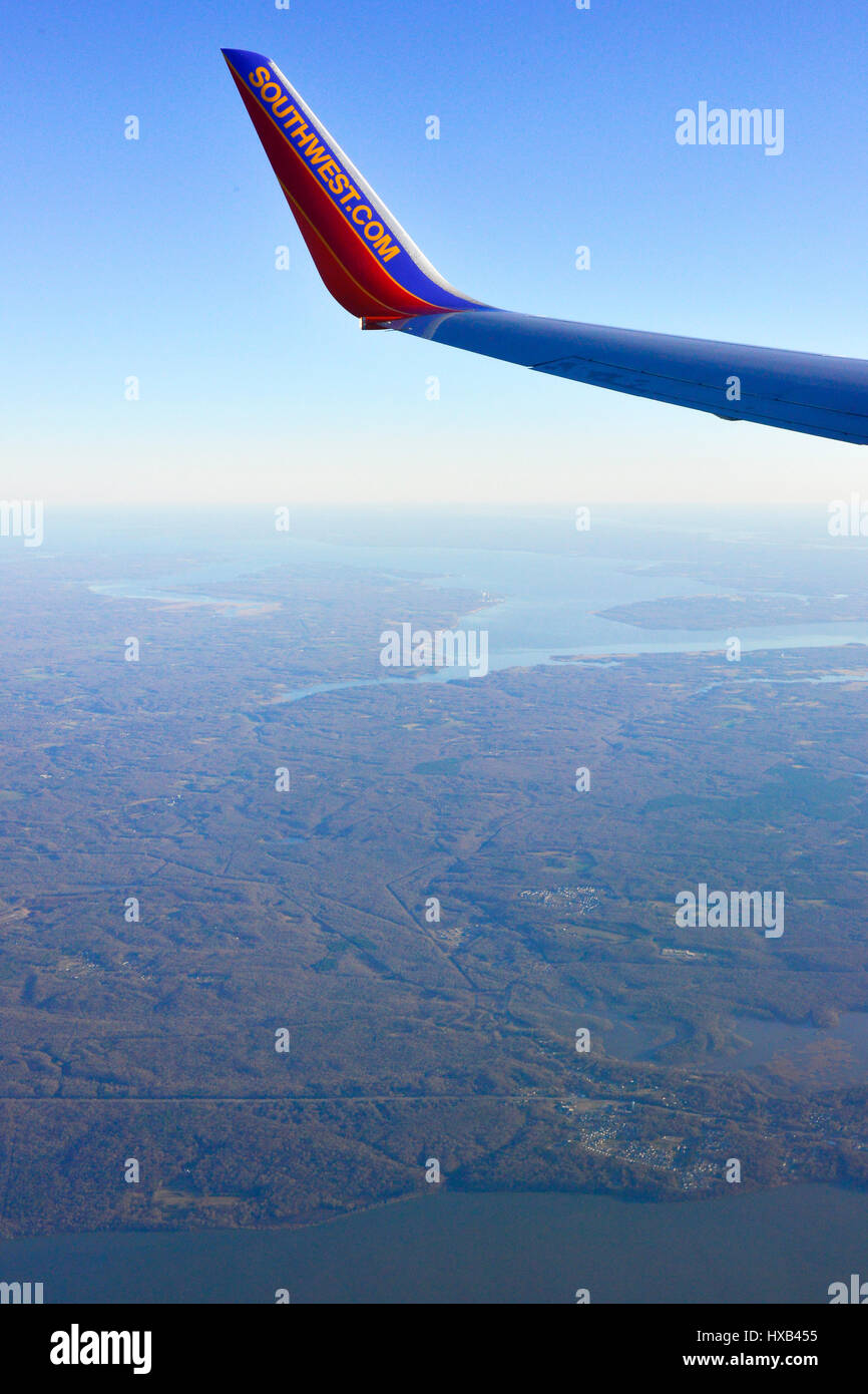 A Southwest Airlines wing tip in foreground as aeriel view over rural landscape below Stock Photo