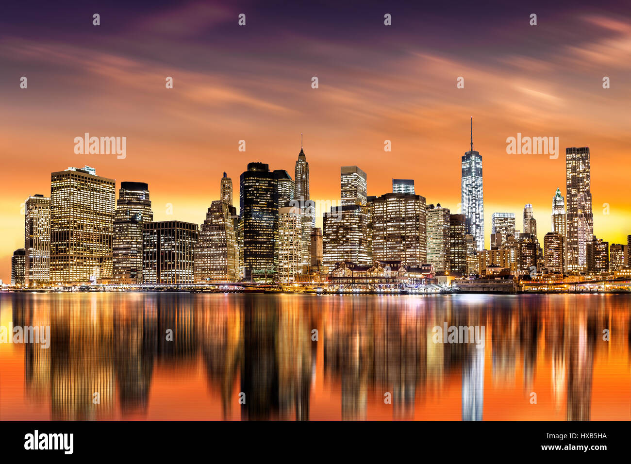 Sunset over New York City's Financial District as viewed from Brooklyn, with skyline reflections in East River Stock Photo