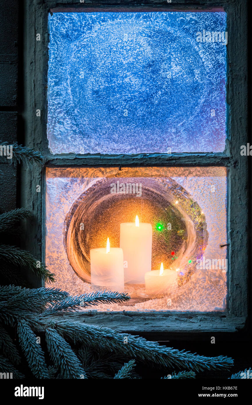 Burning candles for Christmas in frozen window at night Stock Photo Alamy