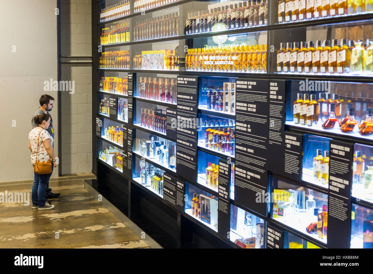 Visitors viewing the Wall of Bundy - a history of Bundaberg Rum products.  Bundaberg, Queensland, Australia Stock Photo