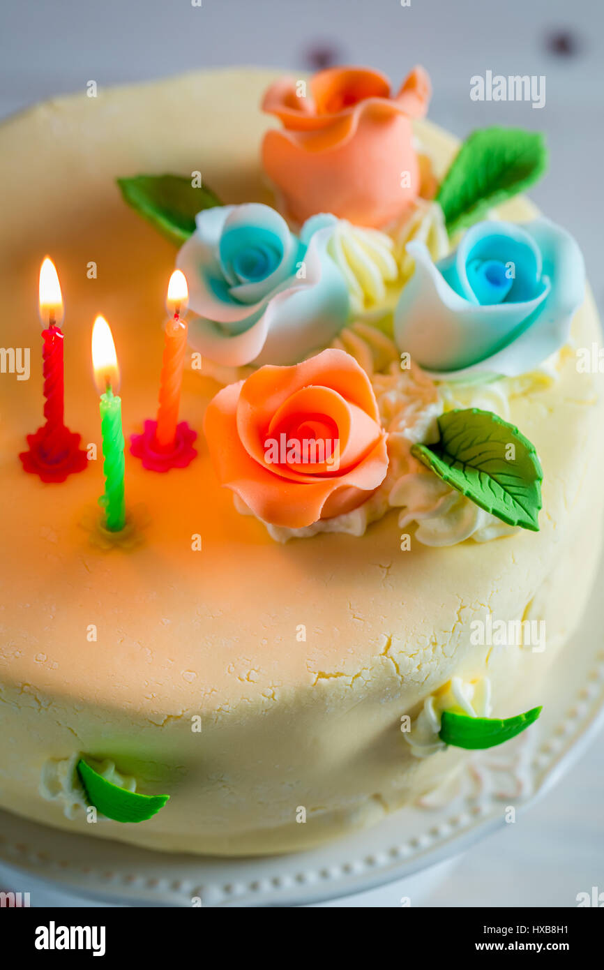Lighted candles and birthday cake on old wooden table Stock Photo - Alamy