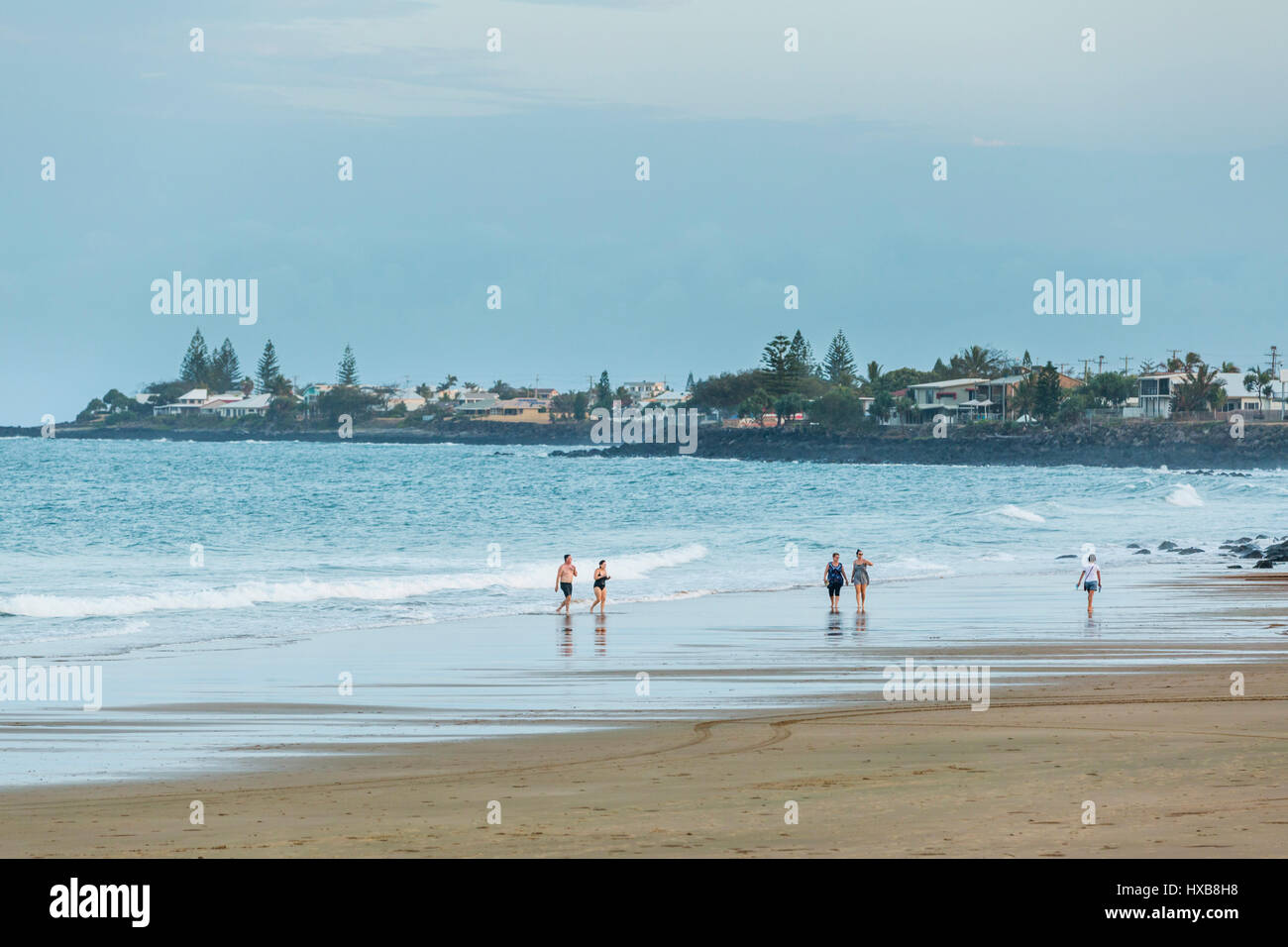 People walking along the sands of Bargara Beach, Bundaberg, Queensland, Australia Stock Photo