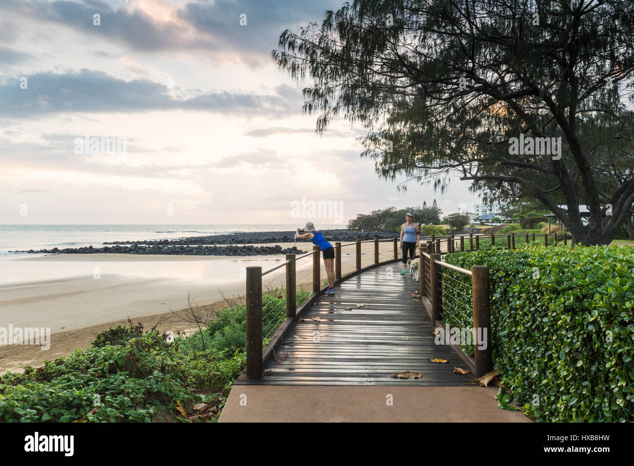 Early morning walkers on the Esplanade boardwalk at Bargara Beach, Bundaberg, Queensland, Australia Stock Photo