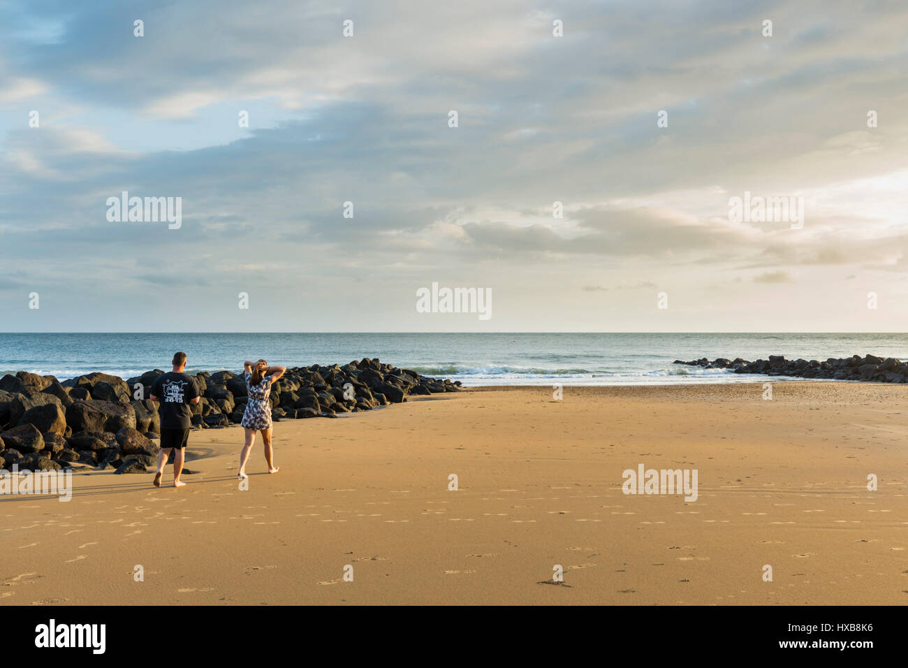 Couple walking along Bargara Beach, Bundaberg, Queensland, Australia Stock Photo